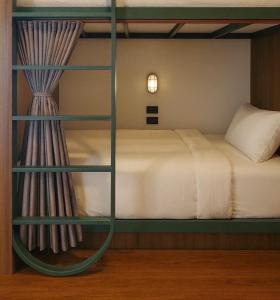 una litera en una habitación con una cama con ventana en กรุงไทย โฮสเทล สเตชั่น, en Thonhuri