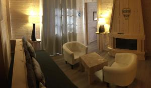a living room with a couch and chairs and a fireplace at Relais Mont Jura Adults Only in Lélex