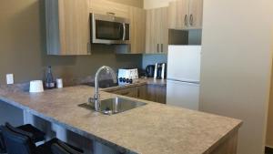 a kitchen with a sink and a white refrigerator at Super 8 by Wyndham Mont Laurier in Mont-Laurier