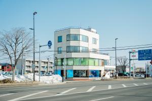 Un edificio alto y blanco al costado de una calle. en Cise Kawakami1, en Kushiro