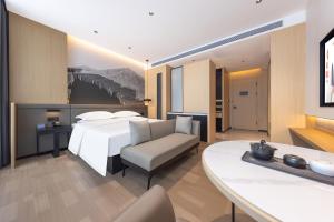 a hotel room with a bed and a table at 锦颐优选酒店呼和浩特巨海城国际会展中心店 in Hohhot +39 photos
