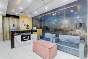 a lobby with two couches and a pink ottoman at Super Hotel O IIM Road Lucknow in Lucknow