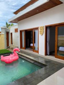 Una piscina con un flamenco rosa en una casa. en Villa Vina by MentariPro Bali, en Singaraja