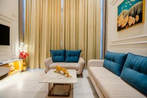 a living room with a couch and blue pillows at Modern Duplex Retreat in Sec 71 in Gurgaon