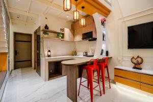 a kitchen with red stools at a kitchen counter at Modern Duplex Retreat in Sec 71 in Gurgaon