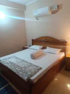 Una cama con dos almohadas encima en una habitación. en JD Homestays, en Jaipur