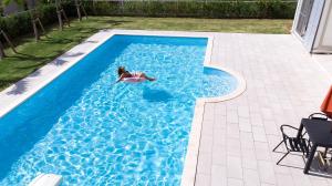 a woman laying on a raft in a swimming pool at Sommelier Villa ISHIGAKI in Ishigaki Island