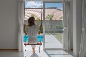a woman sitting in a chair looking out the window at Sommelier Villa ISHIGAKI in Ishigaki Island