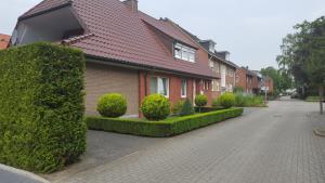 a house with green hedges in front of a street at An der Wilhelmshöhe in Lingen