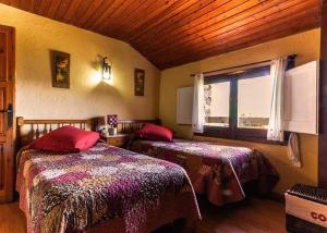 a bedroom with two beds and a window at Masia Can Constans in Queralbs
