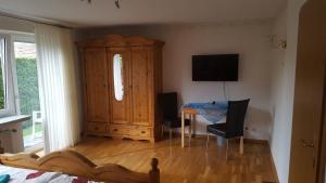 1 dormitorio con armario de madera, mesa y sillas en An der Wilhelmshöhe, en Lingen