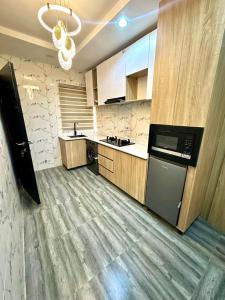 a large kitchen with a stove and a dishwasher at Empyrean Apartments - Cozy & warm two bedroom apartments in Lagos