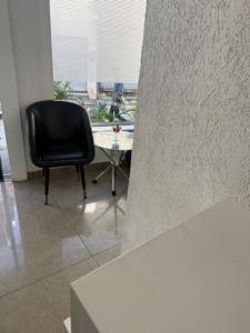 a black chair sitting in a room with a table at Hotel Moon Light in Phagwāra