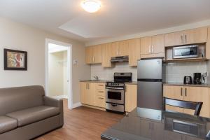 a kitchen with a couch and a stove top oven at Motel Du Fleuve in Brossard