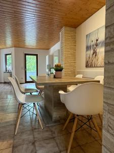BirkenauMonteurwohnung Sander I 4-7 Personen的配有木桌和白色椅子的餐厅 更多8张照片