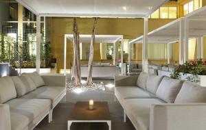 a living room with couches and a candle on a table at Hotel San Teodoro in San Teodoro