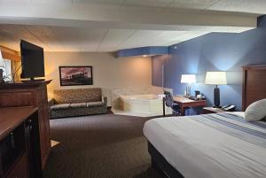 Una habitación de hotel con una cama, un sofá y un televisor. en AmericInn by Wyndham Marshall, en Marshall 18 fotos más