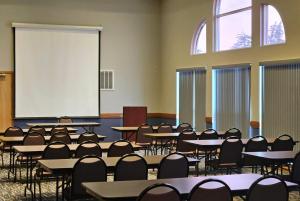 una classe con tavoli, sedie e schermo bianco di AmericInn by Wyndham Marshall a Marshall