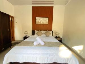 une chambre avec un grand lit avec deux oreillers dessus dans l'établissement Villa Lestari by MentariPro Bali, à Lovina
