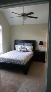a bedroom with a bed with a ceiling fan at Peachtree TownHome in Peachtree City