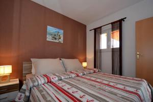 Un dormitorio con una cama grande y una ventana en Apartments Maslina, en Trogir