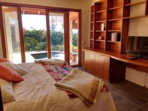 een slaapkamer met een bed, een tv en een boekenplank bij Casa Algarrobo Chile in Algarrobo