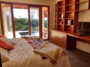 1 dormitorio con 1 cama con TV y estante para libros en Casa Algarrobo Chile, en Algarrobo