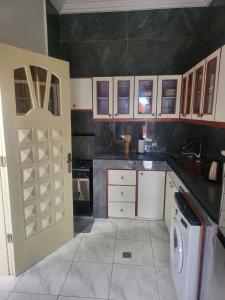 eine Küche mit Waschmaschine und Tür in der Unterkunft Étoile de Justin in Pointe-Noire