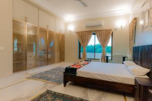 Un dormitorio con una cama y una ventana grande. en The heritage 100, en Jodhpur