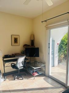 un bureau avec un bureau et une chaise et une porte coulissante en verre dans l'établissement Appartement Limnos Gardens, à Paphos