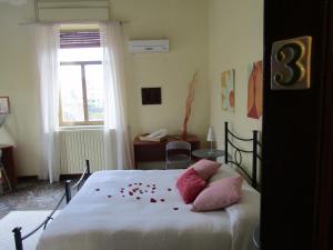 カターニアにあるVilla Libertyのベッドルーム1室(花の飾られたベッド1台付)