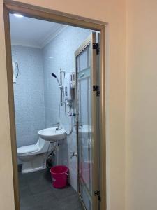 a bathroom with a shower and a sink and a toilet at D'Cottage in Kuala Penyu