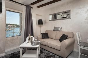 a living room with a couch and a table and a window at Royal Apartments in Rovinj