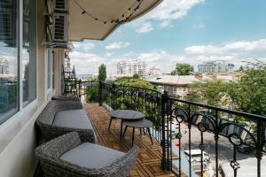 a balcony with chairs and tables and a view of the city at Royal Flowers Apartments in Odesa