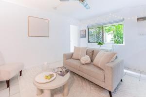 Cairns NorthにあるCosy Stay near Cairns Esplanadeのソファとテーブルのあるリビングルーム