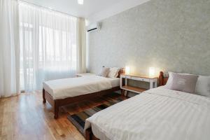 a hotel room with two beds and a window at Royal Flowers Apartments in Odesa