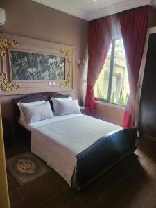 ein Schlafzimmer mit einem großen Bett und einem Fenster in der Unterkunft Justin in Pointe-Noire