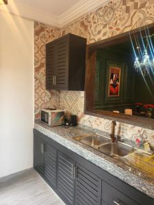 eine Küche mit Spüle und Mikrowelle in der Unterkunft Justin in Pointe-Noire