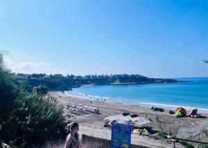 - une plage avec des parasols et des personnes sur la plage dans l'établissement Appartement Limnos Gardens, à Paphos
