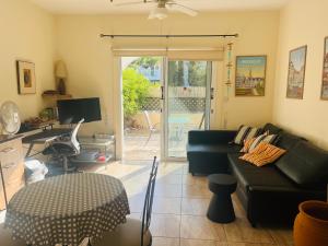 un salon avec un canapé noir et une table dans l'établissement Appartement Limnos Gardens, à Paphos