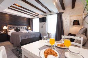 a hotel room with a bed and a table with food at Royal Apartments in Rovinj