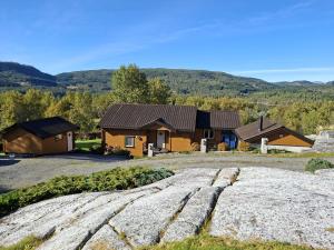 ein Haus mit einem Berg im Hintergrund in der Unterkunft Moderne hytte på Tingvoll nær sjø og turterreng in Tingvoll