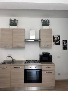 a kitchen with wooden cabinets and a stove top oven at Appartamento Sardinia Escape in residence - Palau in Palau