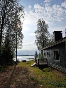 a house next to a body of water at Kuikkaniemen Rantamökki in Ranua