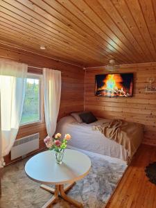 a bedroom with a bed and a fireplace in a room at Kuikkaniemen Rantamökki in Ranua
