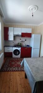 a kitchen with red cabinets and a white stove at Gabala,yard, house in Gabala