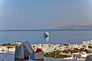 una nave da crociera in acqua vicino a una città di Ibiscus Boutique a Mykonos Città