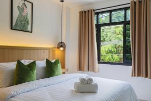 ein Schlafzimmer mit einem Bett mit zwei Handtüchern darauf in der Unterkunft Wink Hill 1 Penthouse Patong 4 Bedrooms in Patong Beach