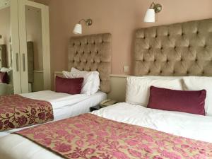 Łóżko lub łóżka w pokoju w obiekcie Maples House Hotel
