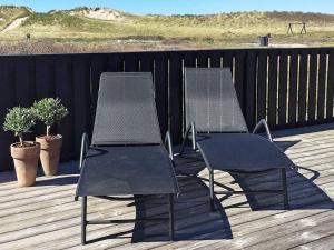two chairs sitting on top of a deck at 8 person holiday home in Hjørring in Hjørring